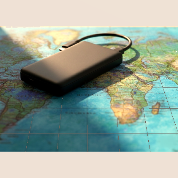 A sleek, dark gray portable travel charger resting on a vibrant, abstract world map background, symbolizing global travel and exploration.